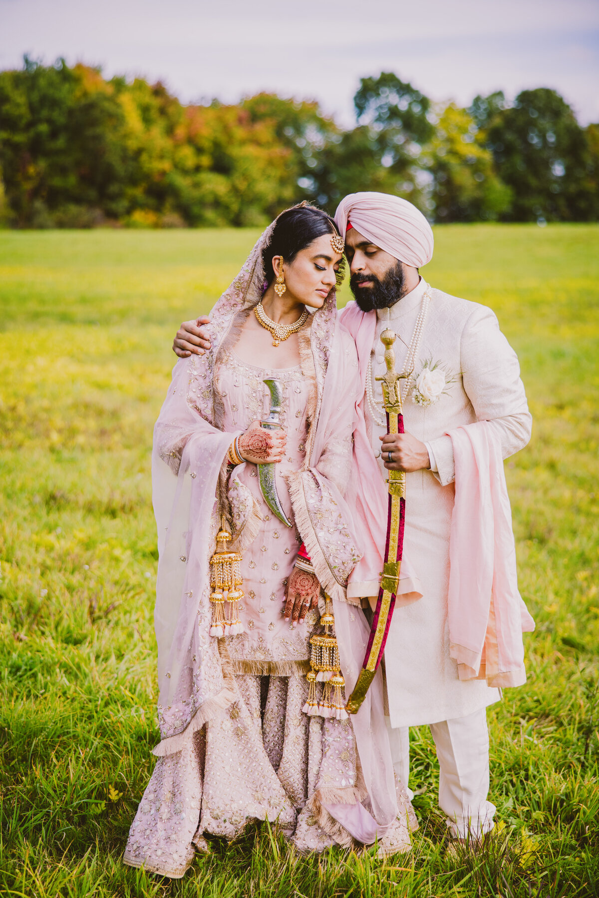 Sikh bride and groom both holding kirpans share a moment after the wedding in southington ct