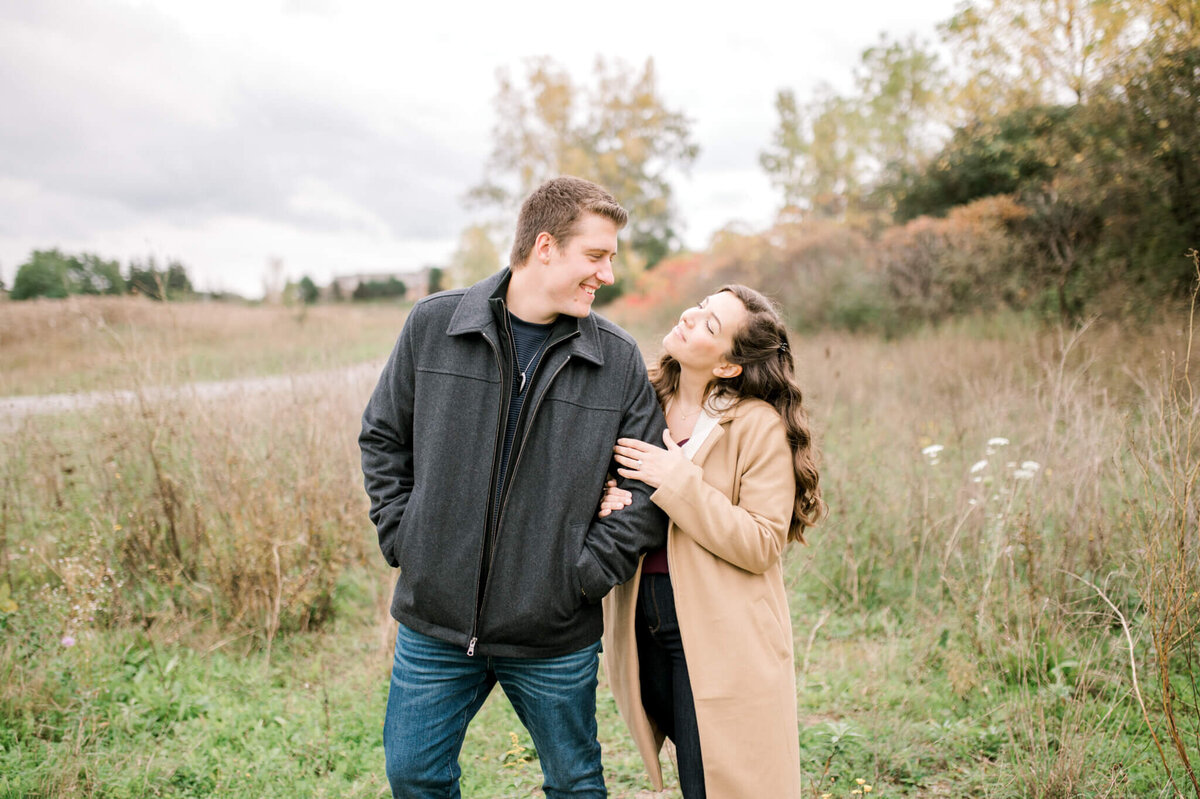 Engaged couple posing in a field