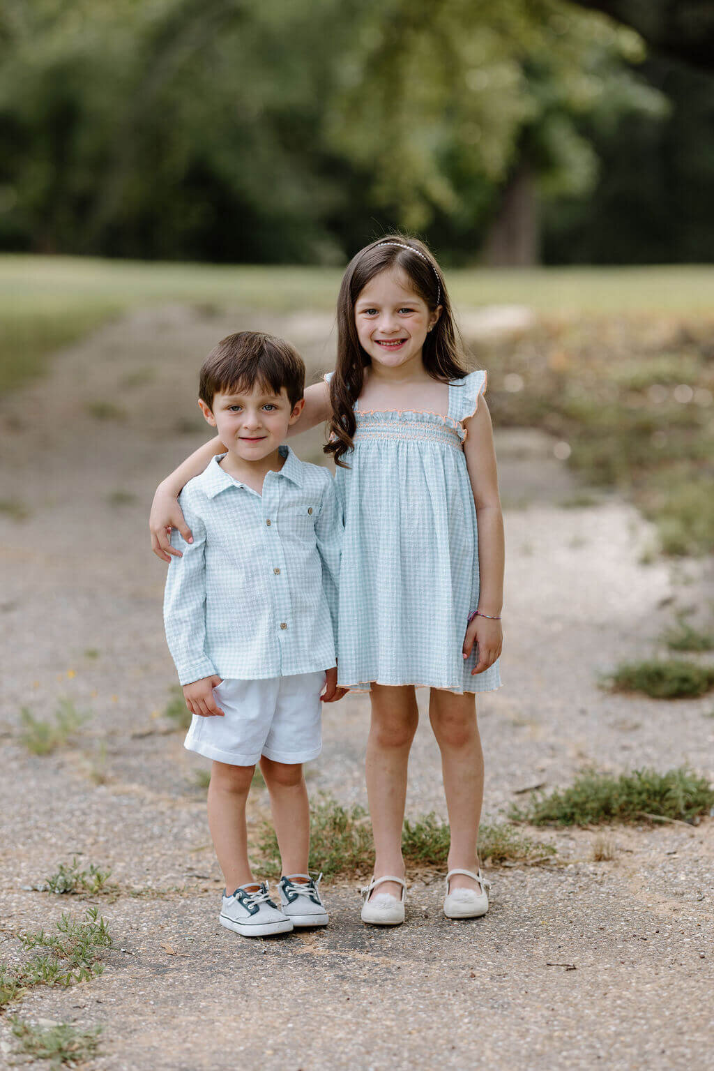 picture of 2 siblings hugging under oak tree