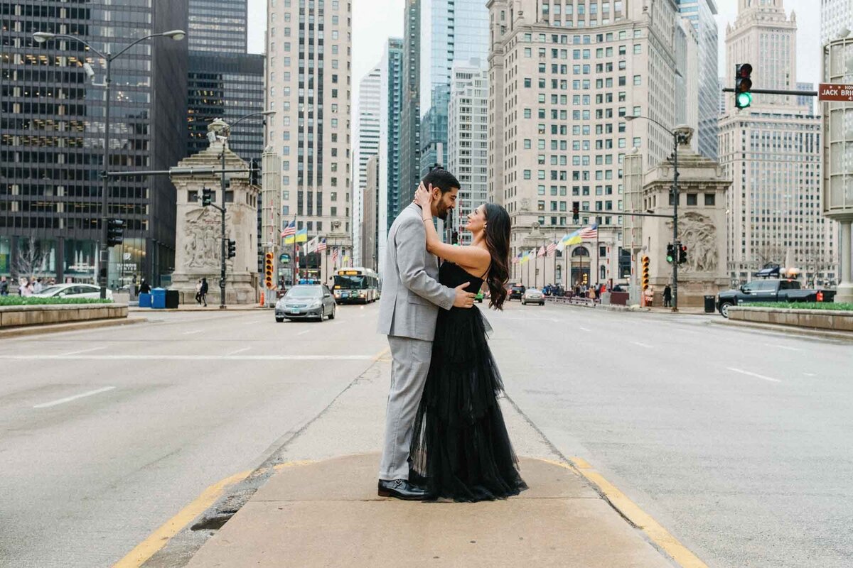 Couple pose in the middle of Chicago's Mag Mile for an engagement photo