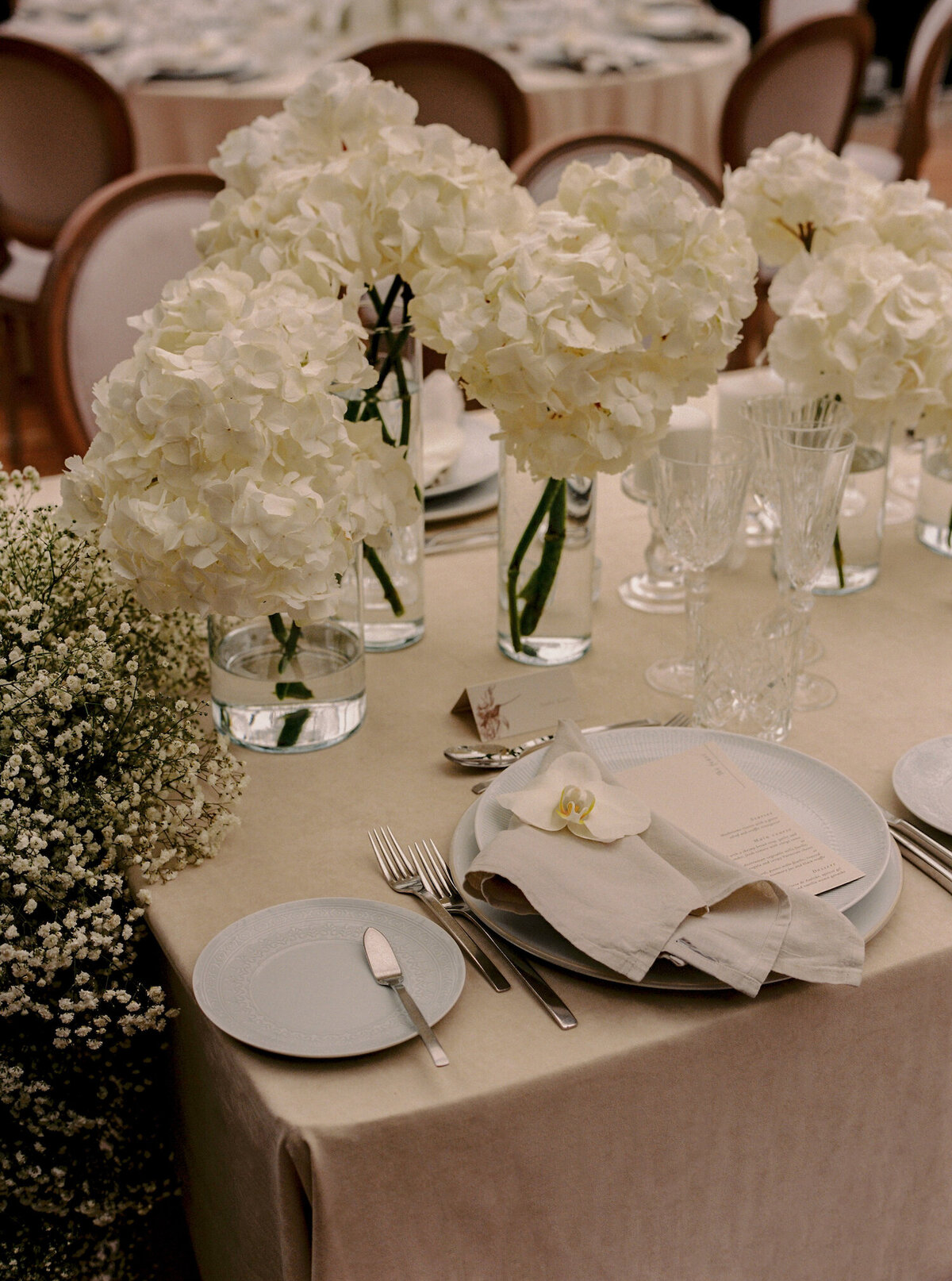 A Quinta da Bellavista destination wedding table decorated with white hydrangea flowers and babies breath flowers and Vista Alegre plates