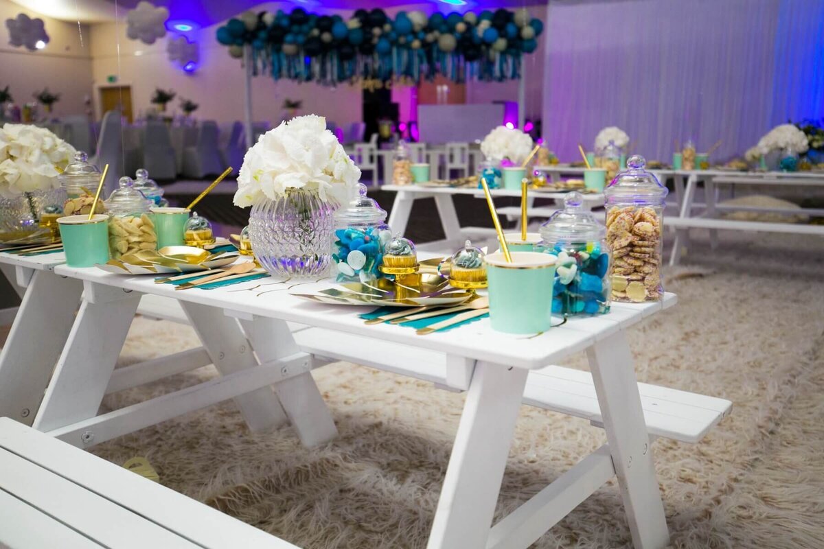 Party table decoration with turquoise cups and white flowers