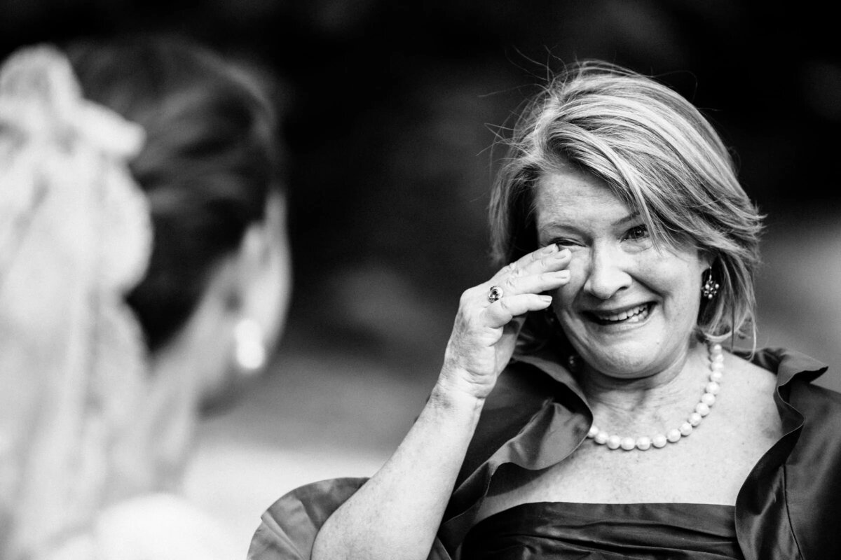 An emotional moment where a woman wipes away a tear during a wedding