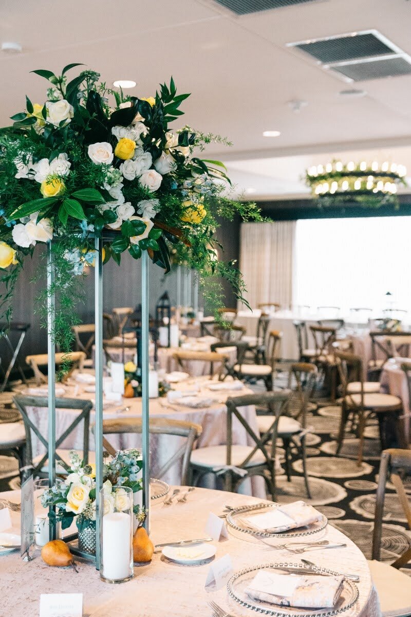 Large floral arrangement centerpiece at indoor wedding reception.