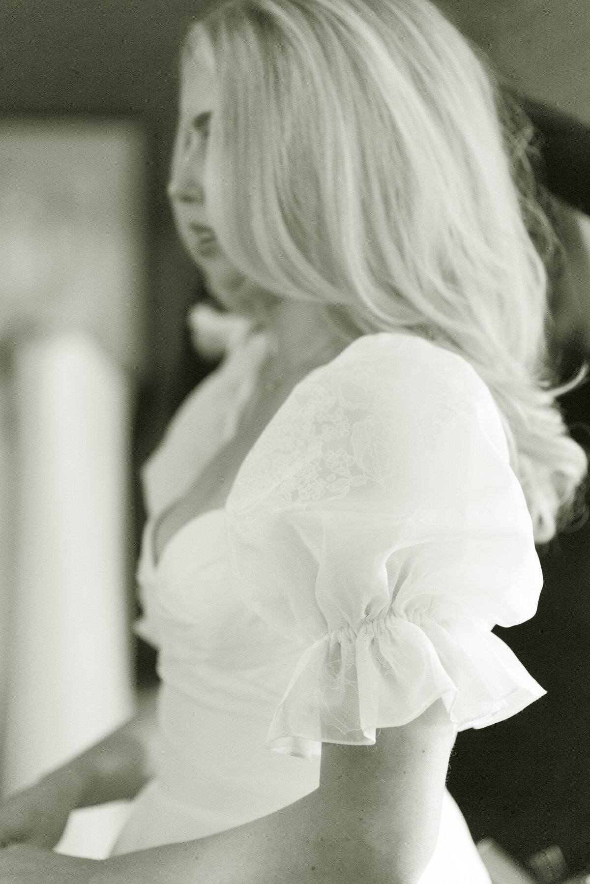 Bride with voluminous wedding hair, wearing bespoke patterned puff sleeve wedding dress on her wedding morning in the Bridal Suite of Cromlix House.