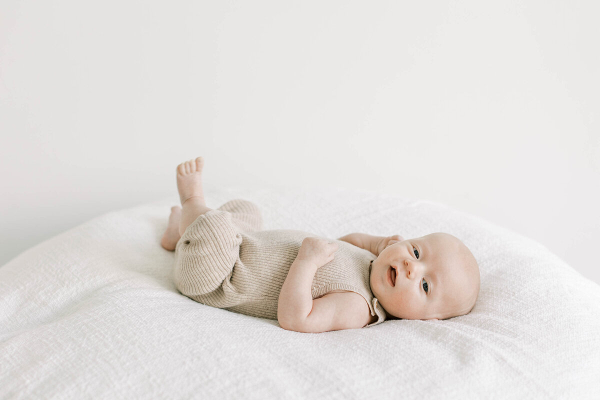 Sleeping baby on white blanket during newborn session