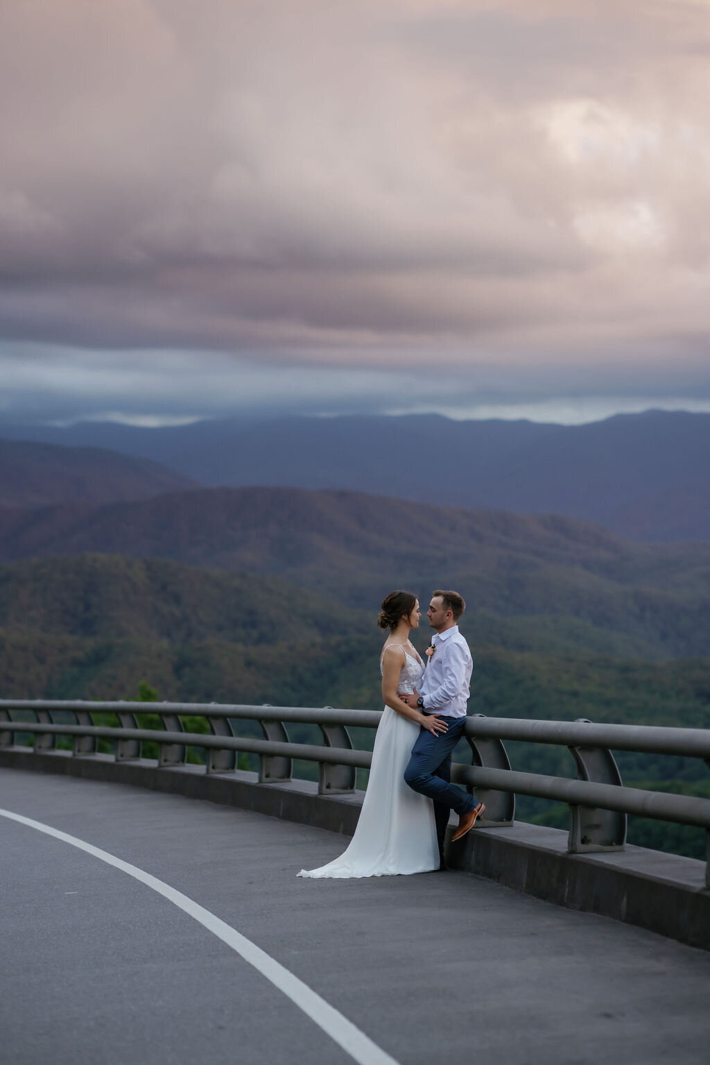 foothills parkway Tennessee elopement photos of bride and groom kissing while standing together on the road