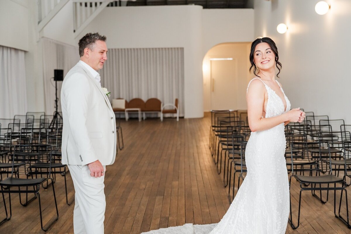 Bride looking over her shoulder at the groom during a first look