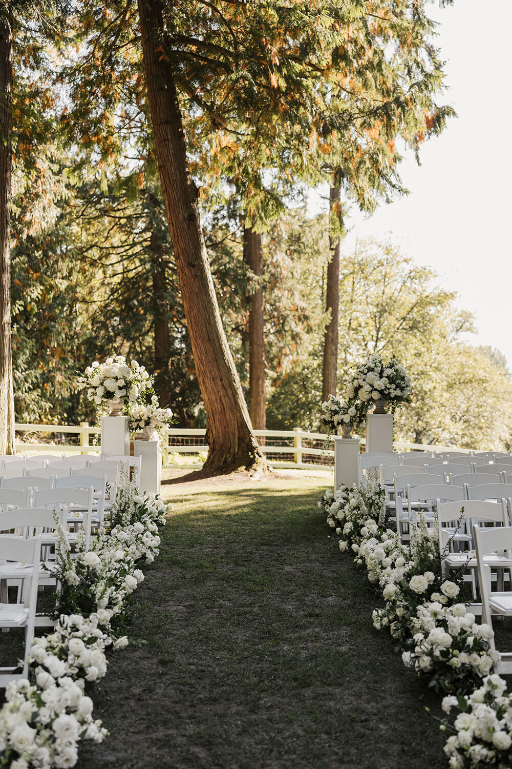 Aisle lined with white florals for an outdoor ceremony