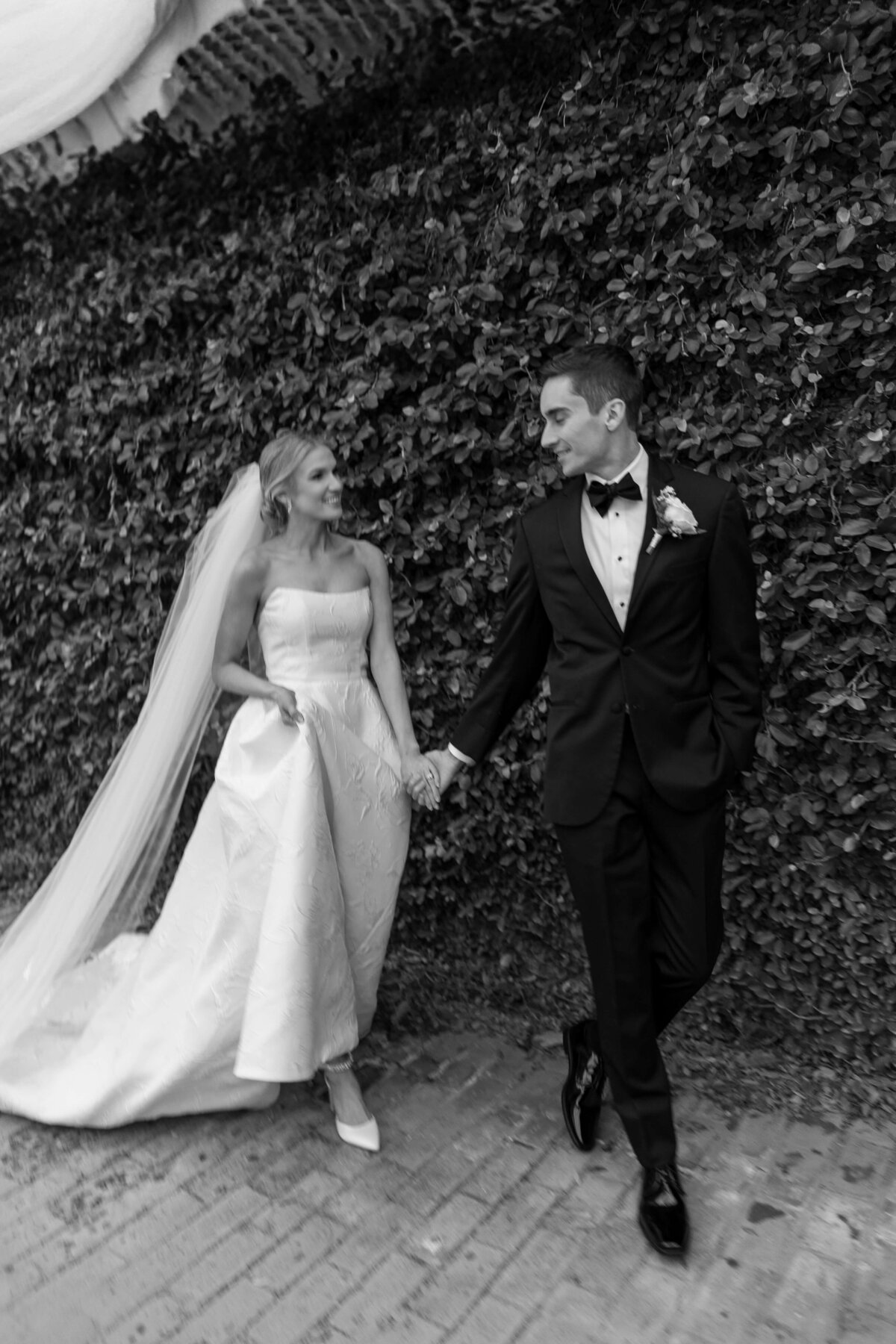 A bride and groom walk through downtown Savannah