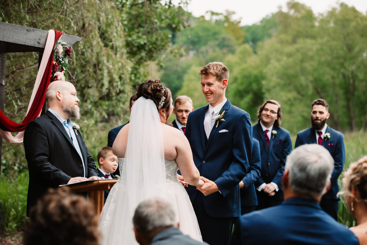 A bride and groom hold hands during their ceremony