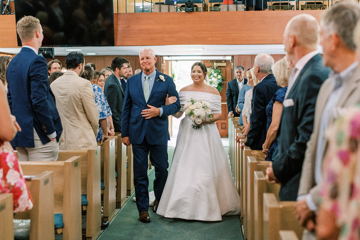 Bride walking down the aisle with her father during a church wedding ceremony in Cashiers NC