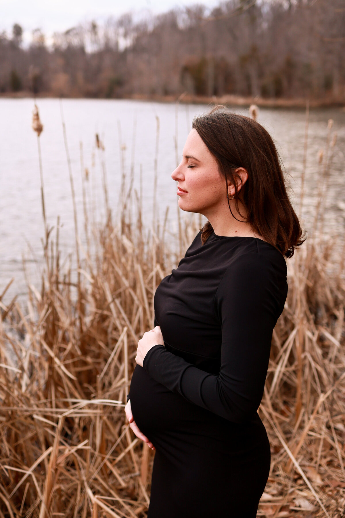 pregnant woman holding belly in park in Atlanta Georgia by maternity photographer Amanda Richardson Photography