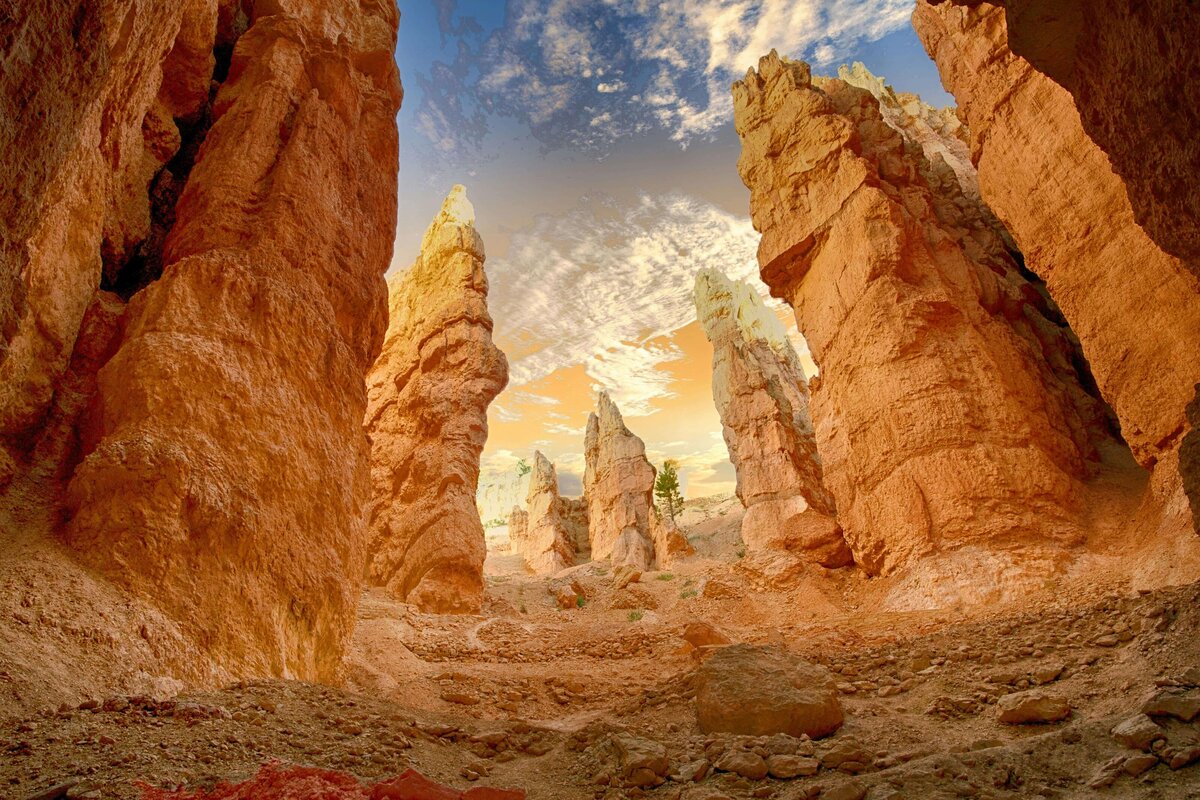 A breathtaking view of Bryce Canyon, showcasing towering red rock formations under a dramatic sky with warm golden hues. This natural wonder highlights the awe-inspiring destinations available through vacation fundraising for charities.