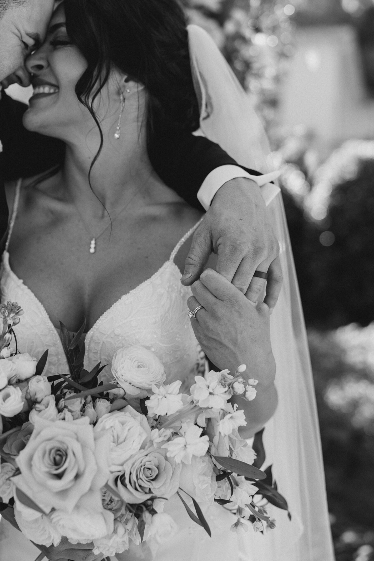 A bride and groom holding hands next to a bouquet