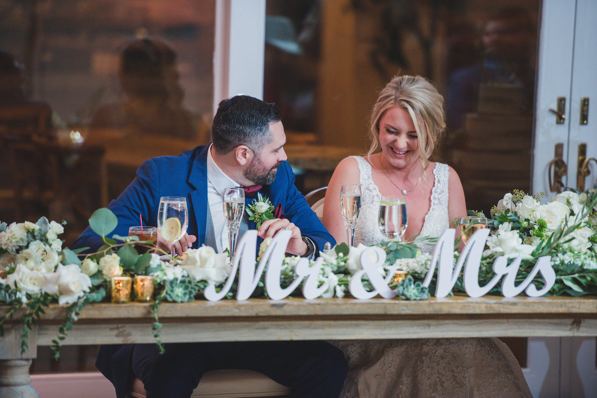 bride and groom sitting at dais table during wedding reception at The Vineyards at Aquebogue