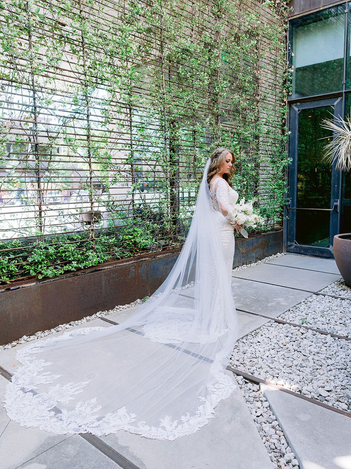 The bride poses in the atrium of the South Congress Hotel with her veil falling behind her