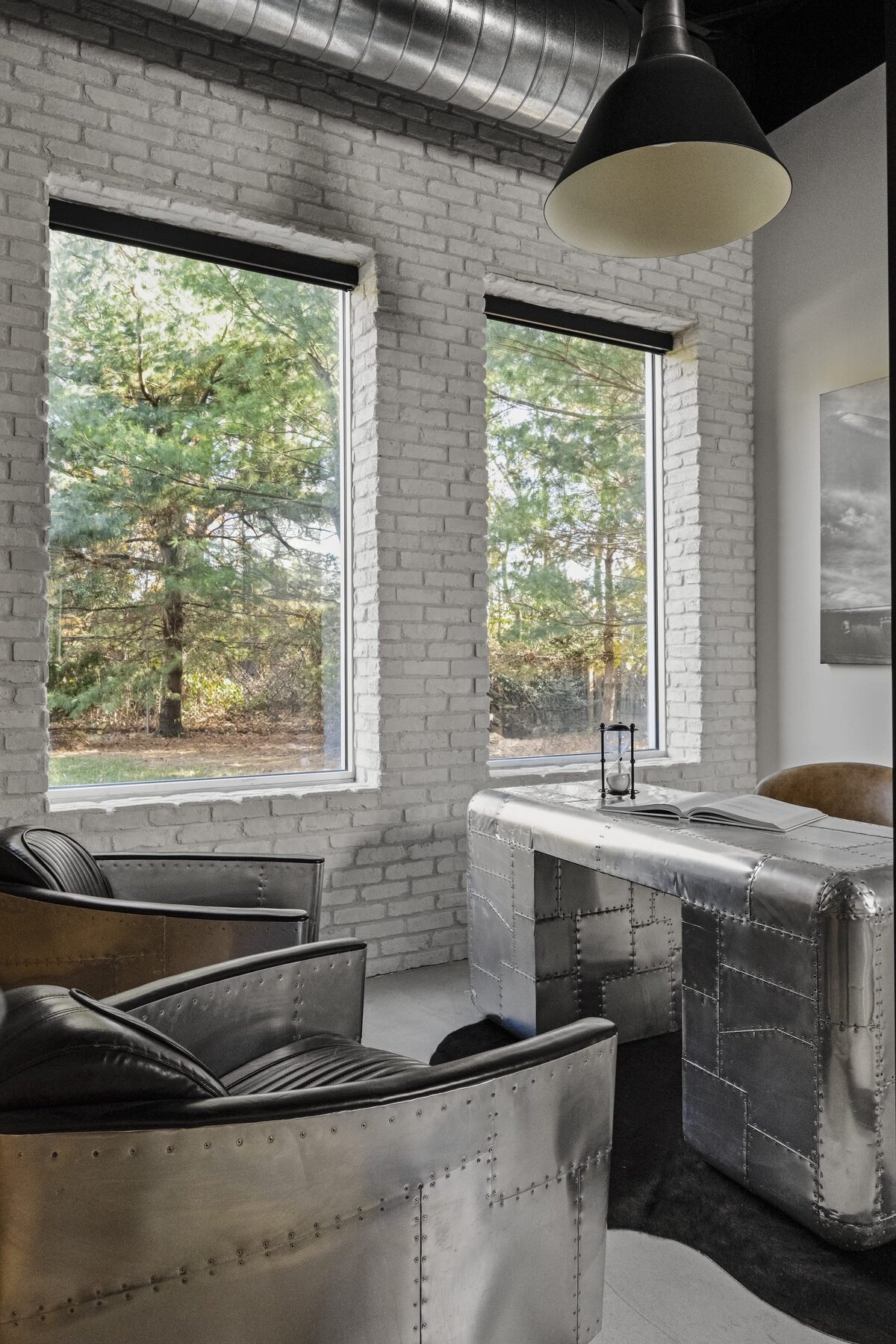 candra lynn interiors old bridge project large white brick wall with windoes and metal office desk and chairs