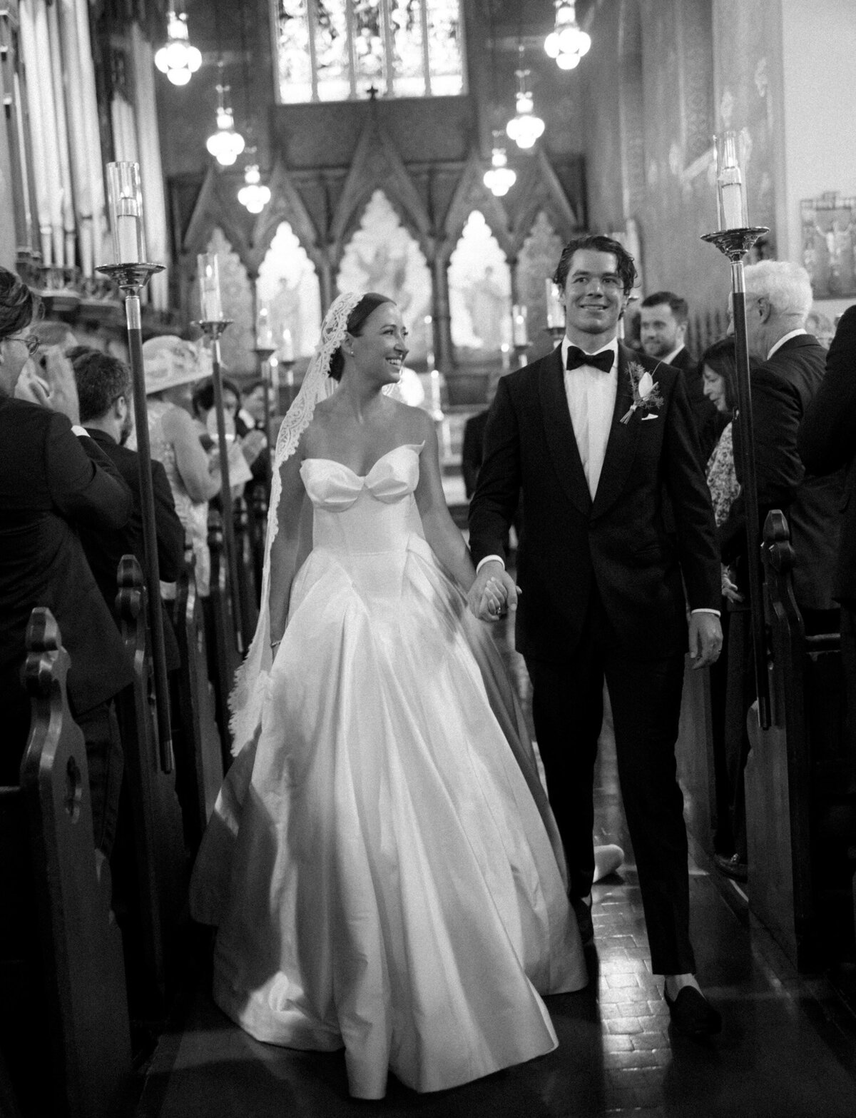 A bride and groom walk down the aisle laughing after being married at Christ Church, Detroit