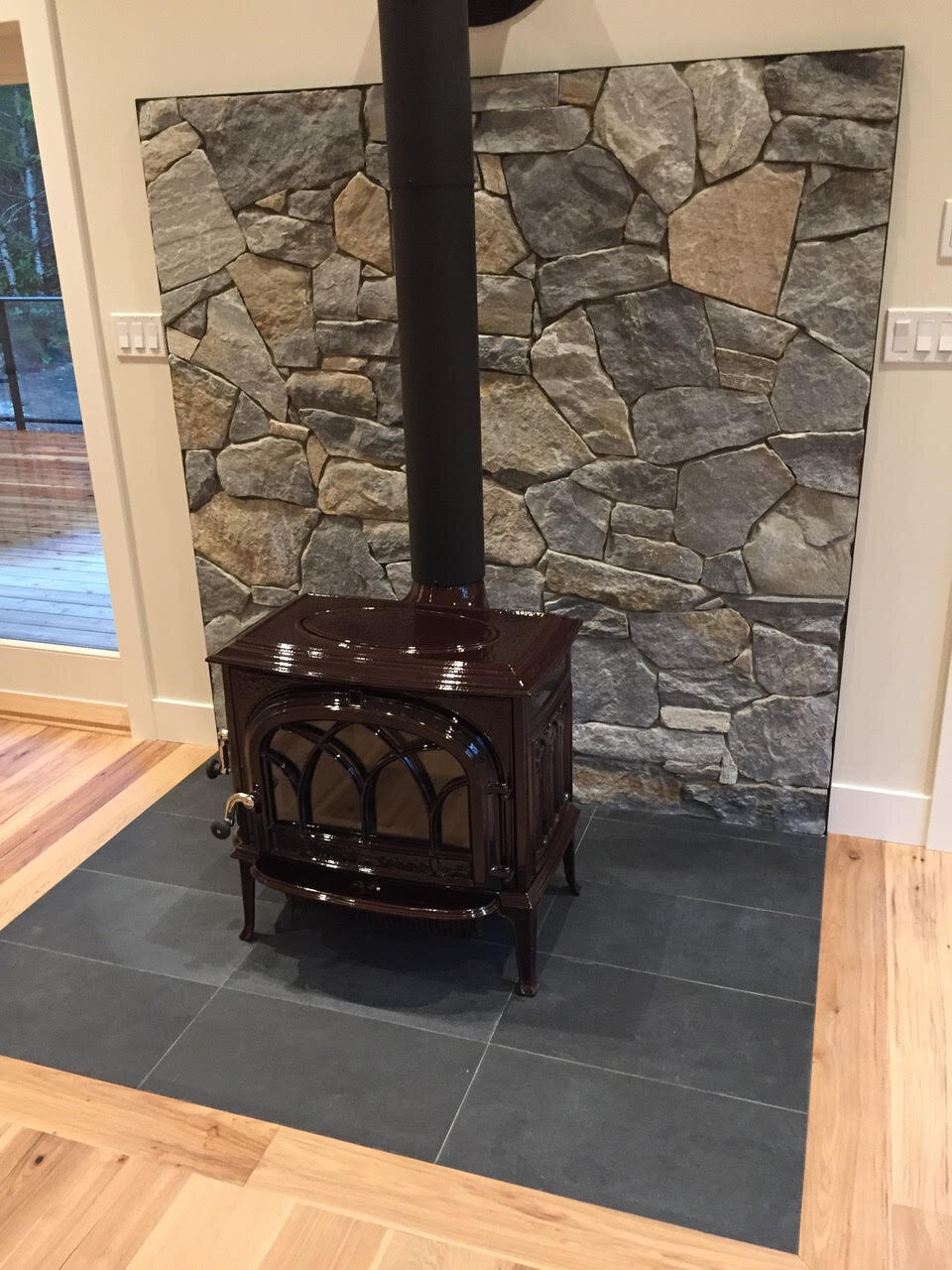 Black wood burning fireplace with rock surround.