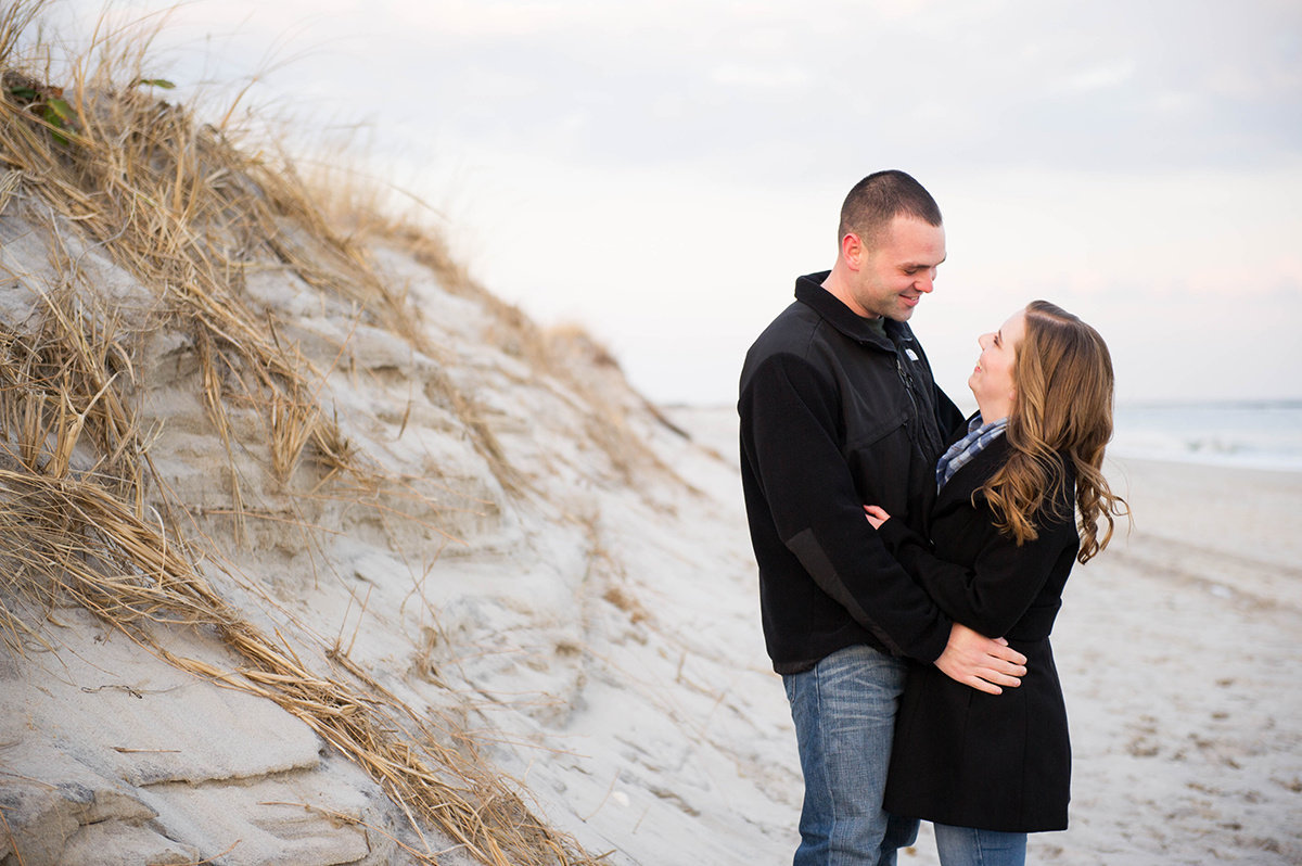 couple take engagement photos in winter on beach