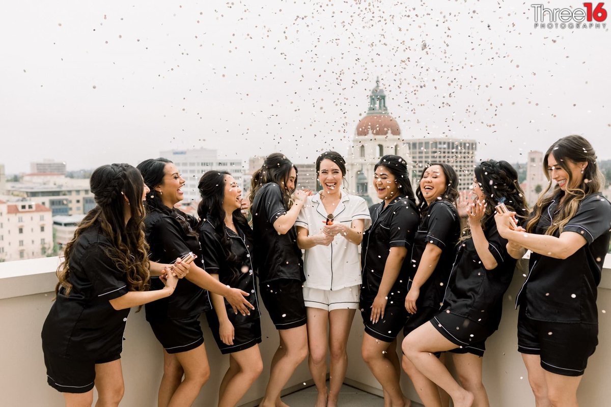 Bride and Bridesmaids shoot off confetti on the rooftop before getting dressed for the wedding ceremony
