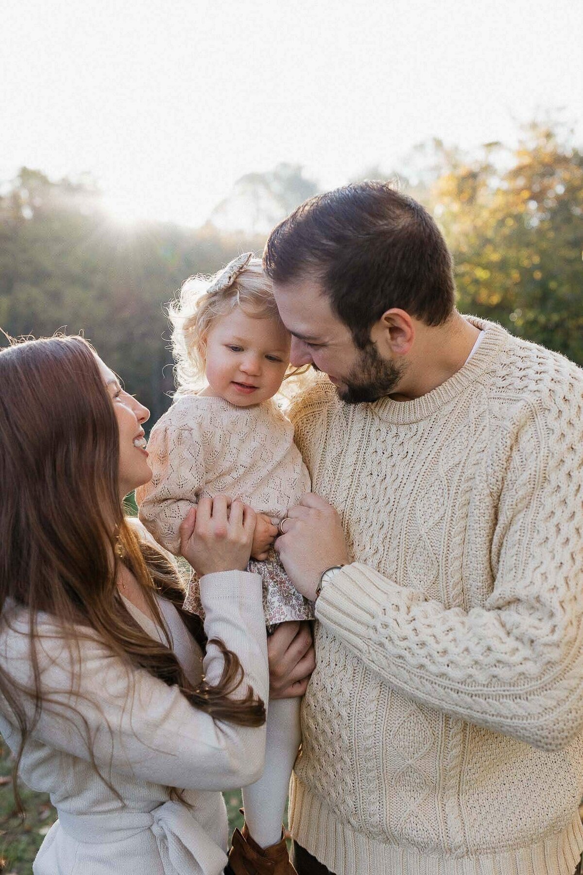 Family snuggling in a Cleveland field during fall family photo session.
