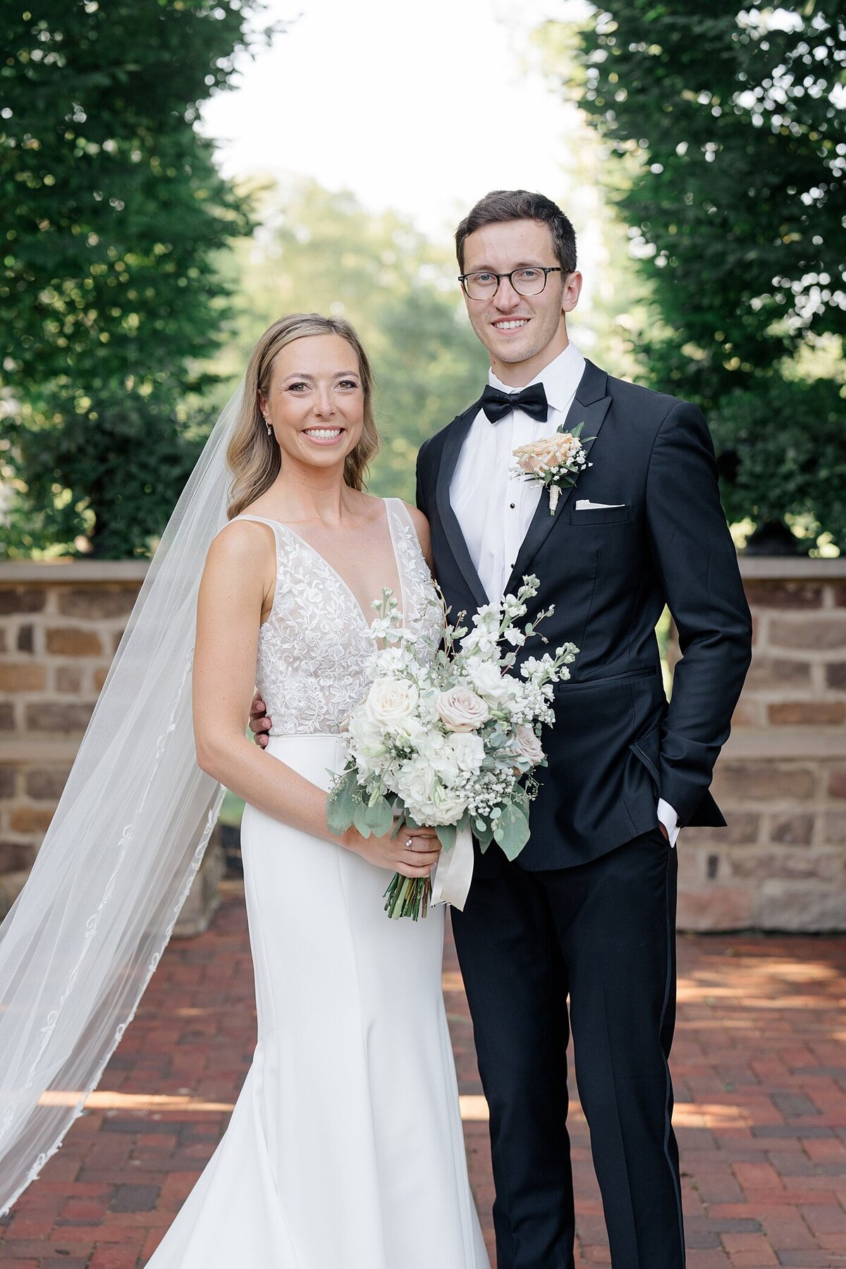 Pinnacle Gold Club wedding photos with bride and groom posing in a courtyard with brick pillars and patio