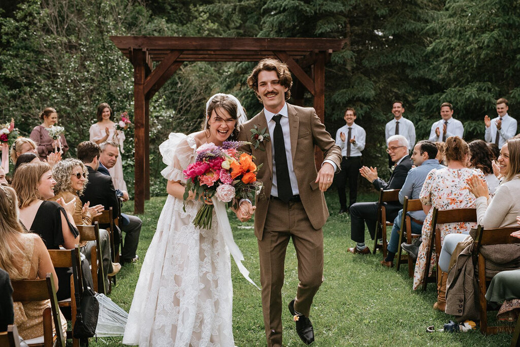 Colourful outdoor summer ceremony at The Valley Weddings, a rustic and majestic wedding venue in Westerose, Alberta, featured on the Brontë Bride Vendor Guide.