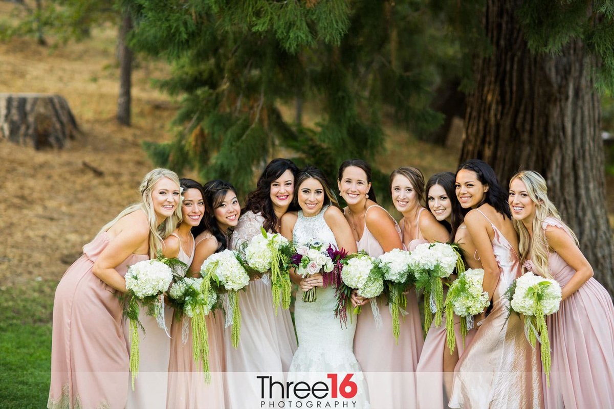 Bride poses with her Bridesmaids as the squeeze in together
