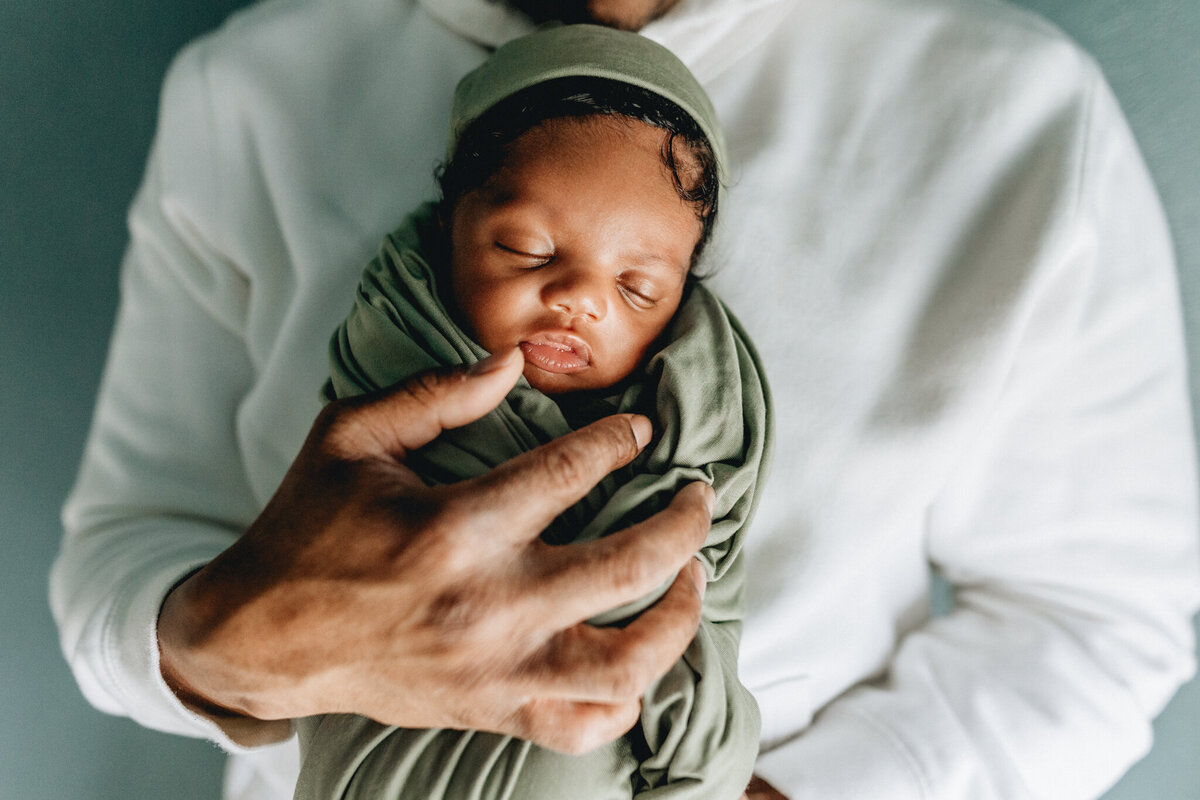 Family photography of dad holding newborn baby