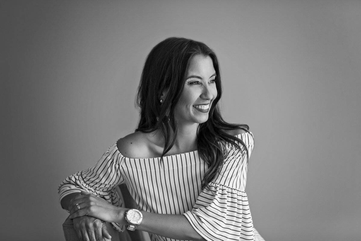 a black and white image of a woman in a stripped shirt with long brown hair during her philadelphia headshot session