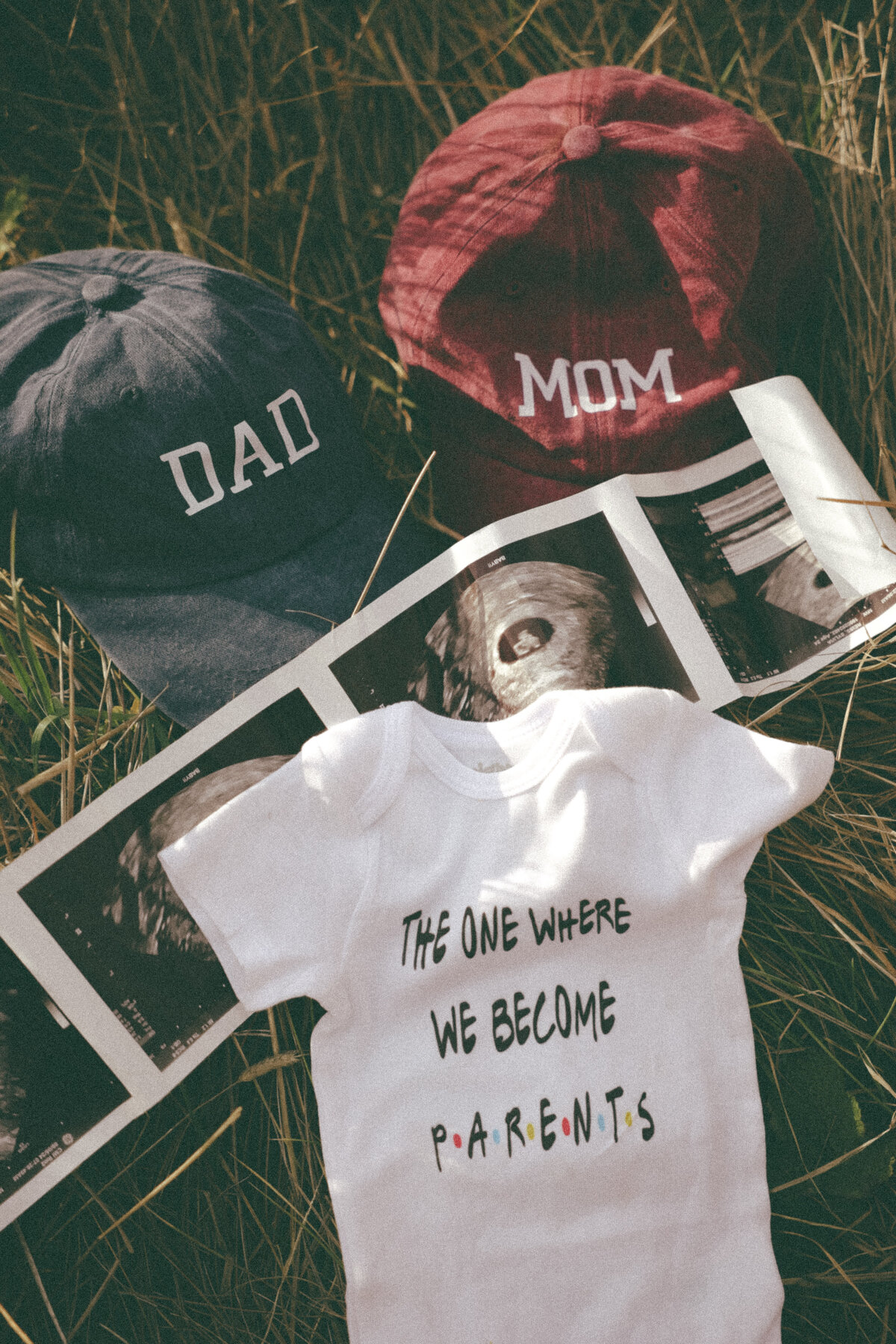 Flat Lay Pregnancy Announcement with Baby Onesie and Ultrasound Photos