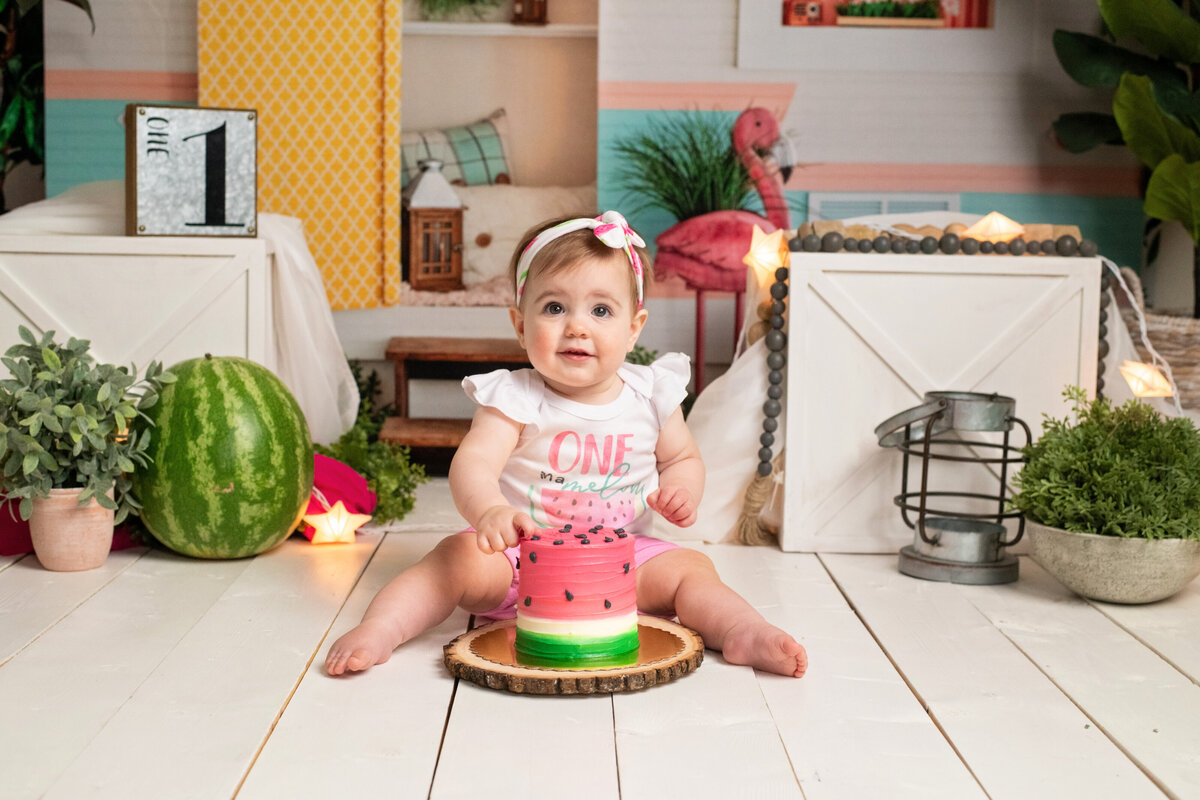 Happy baby girl with watermelon birthday cake