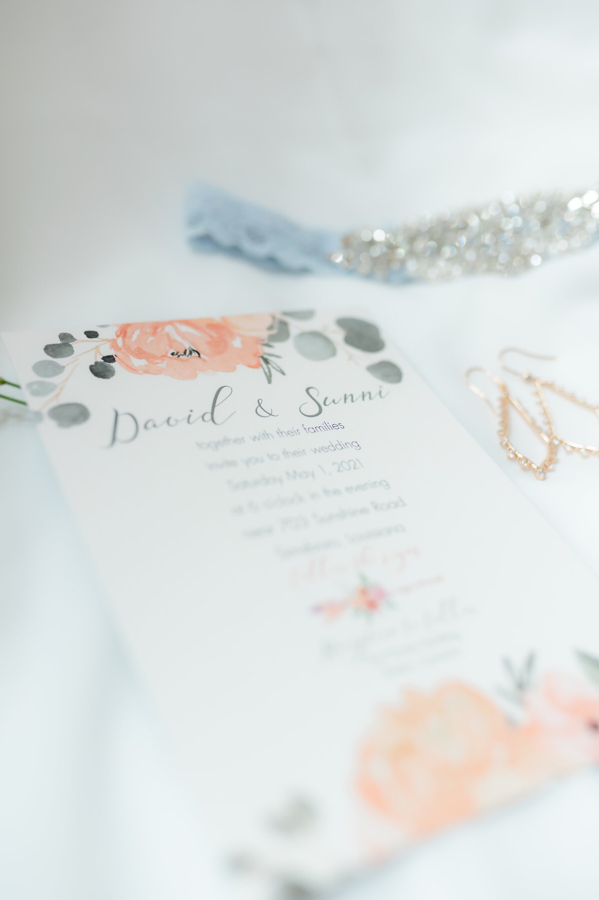 wedding invitation with pink florals and dark blue cursive for an elegant wedding