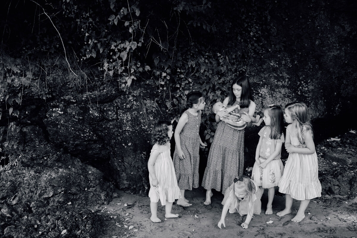 group-of-children-looking-at-baby-on-beach