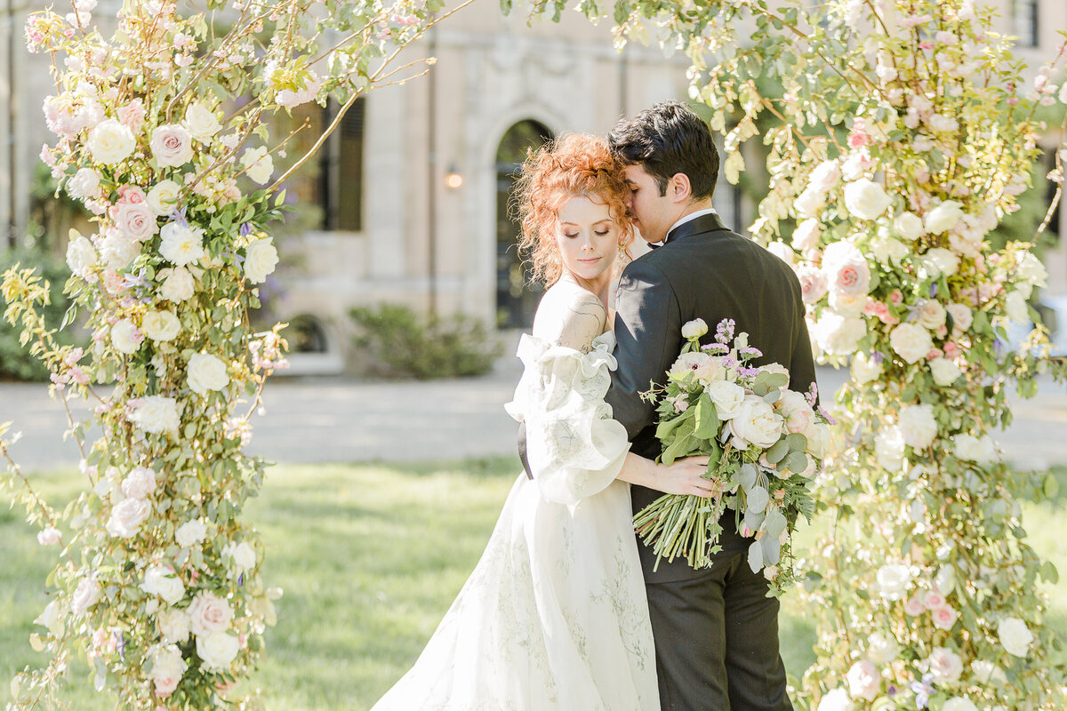 Bride and groom snuggle for an intimate wedding portrait. The bride is facing the groom and he is whispering intimately in her ear. Captured by best Massachusetts wedding photographer Lia Rose Weddings