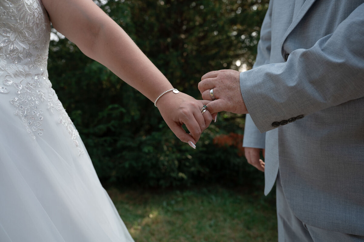 bride and groom locking fingers showing off wedding rings at Northwich St Mary's Church Wedding