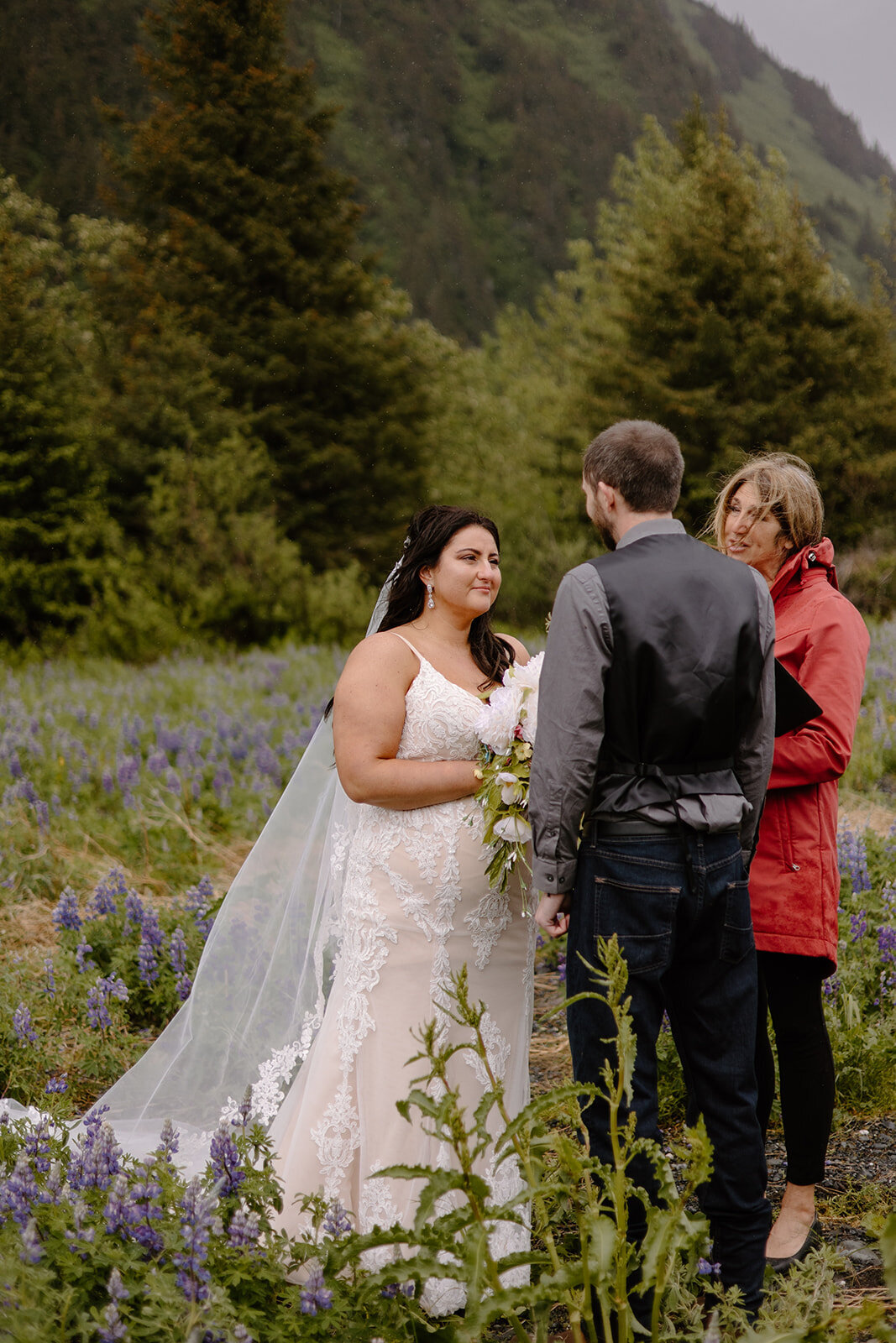 Elopement couple recites vows in flower field with mountain view.