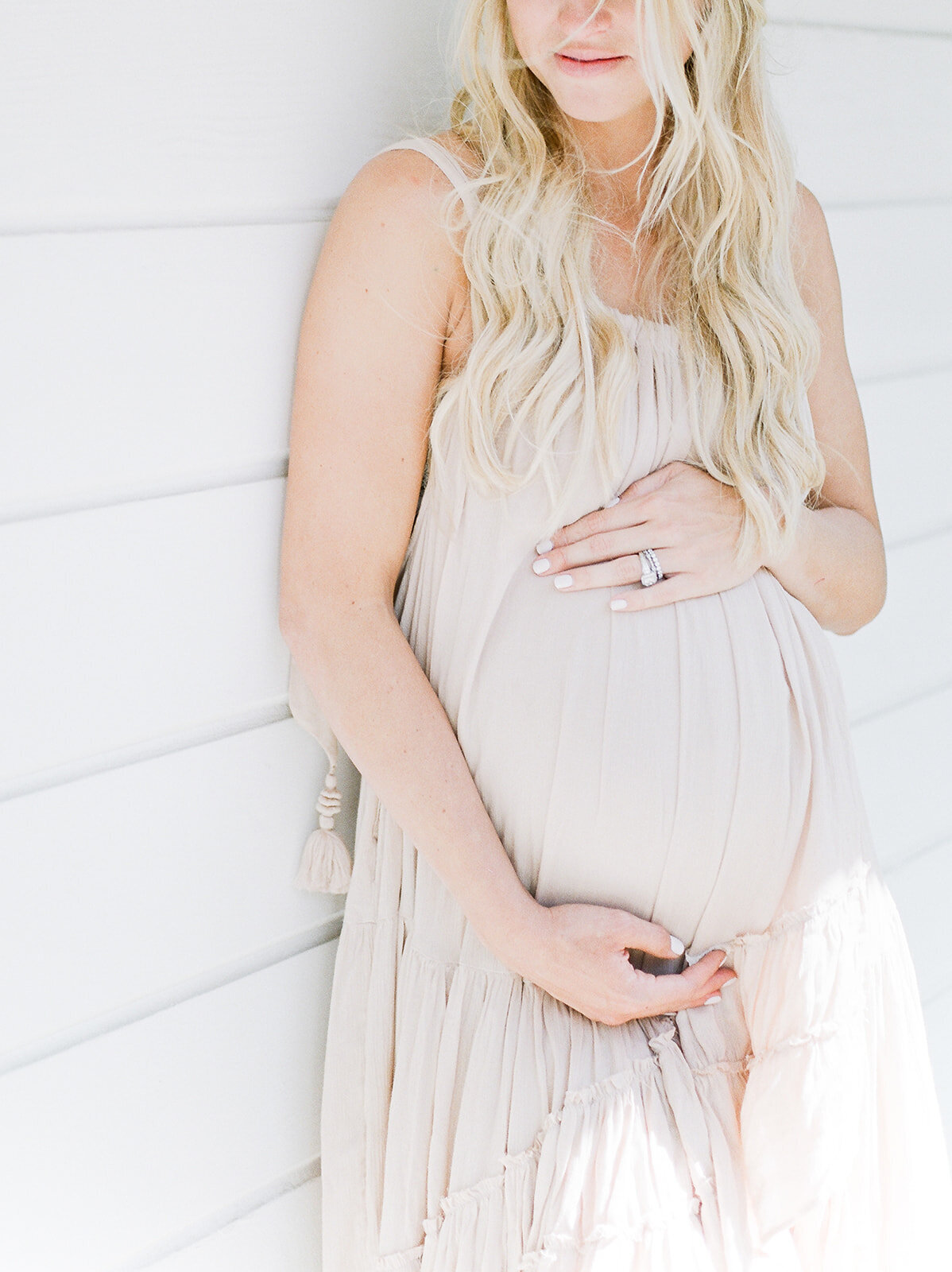 expecting mama in blush as she awaits baby's arrival on a sunlit porch by Orlando maternity photographer.
