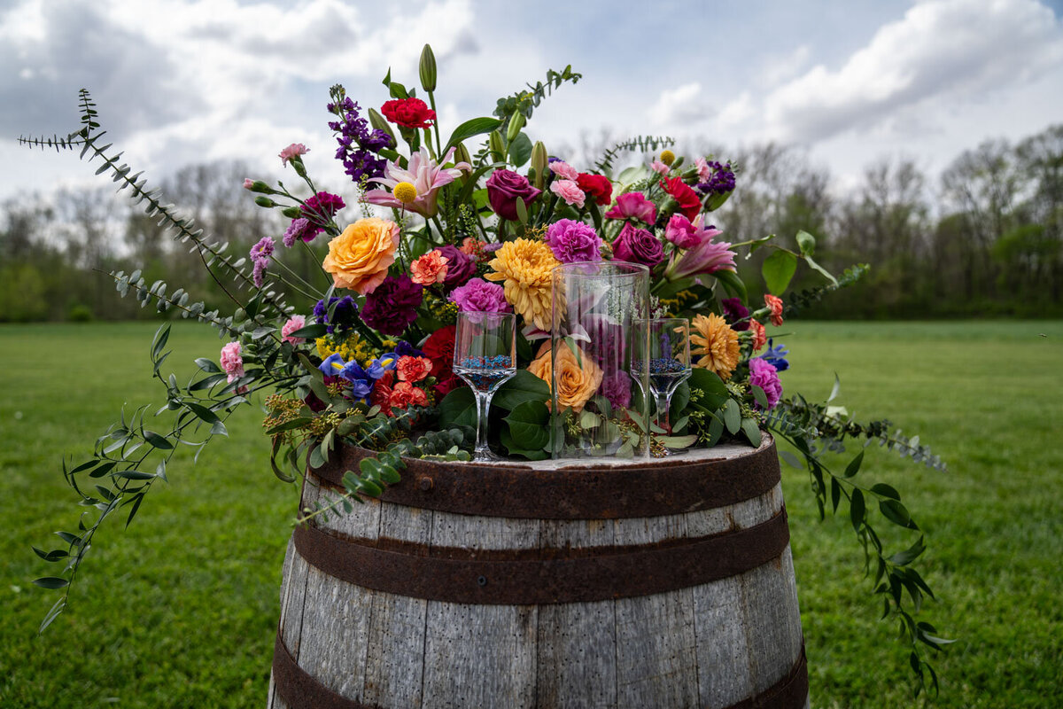 Vibrant floral arrangement on a rustic wine barrel