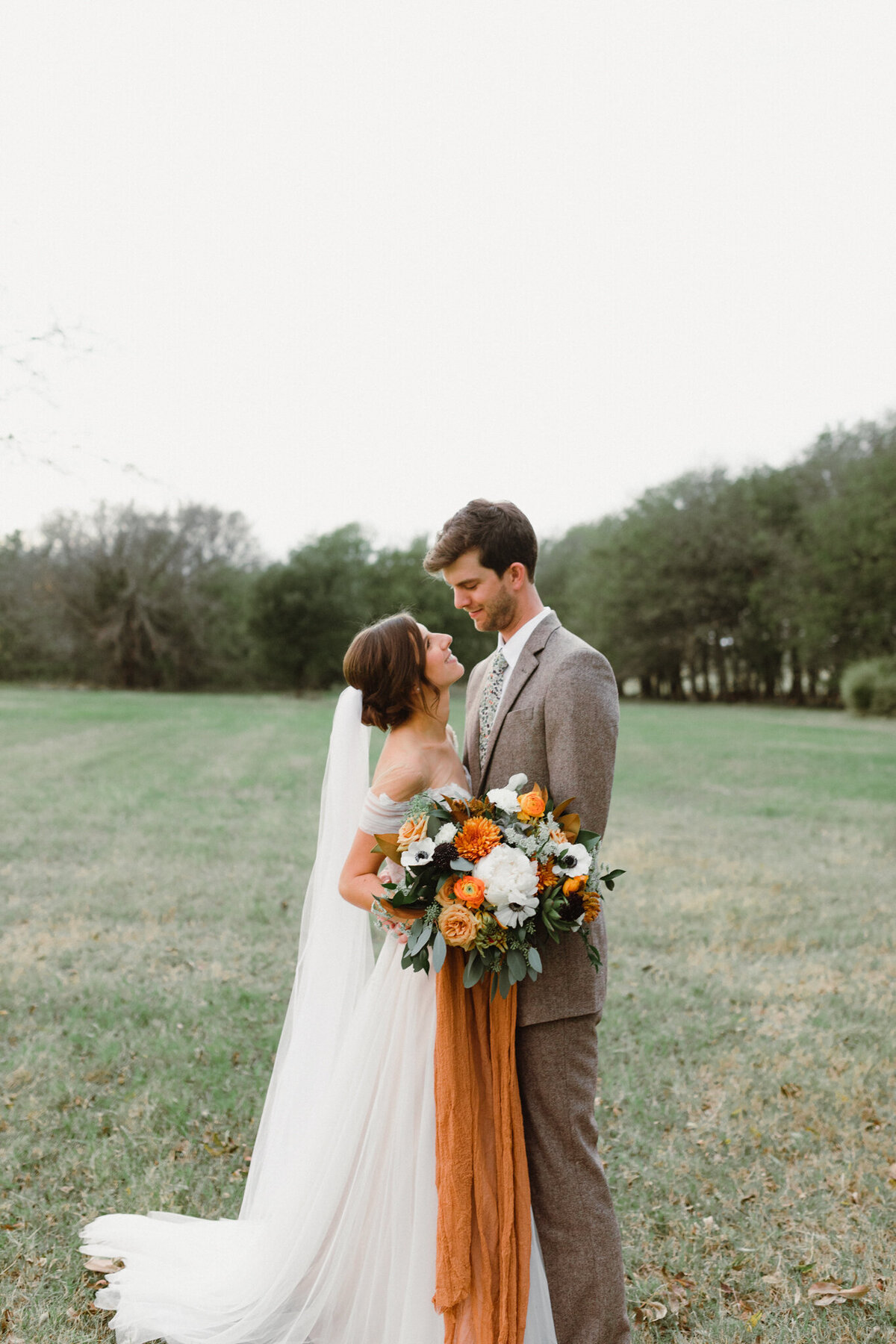 Elopement Photography, bride and groom standing in large field looking at each other