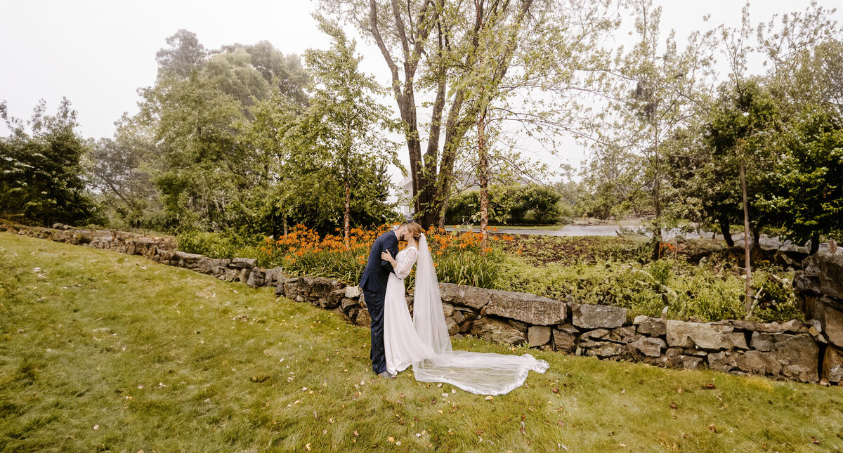 couple on their wedding day kissing in grass field