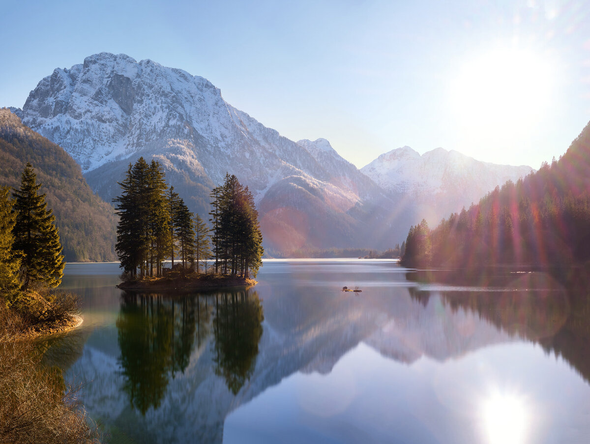 Zauberhafte Gegenlichtaufnahme vom Lago di Predil im Winter – professionelle Landschaftsfotografie mit Fokus auf Alpenpanoramen von Fotograf aus Österreich.