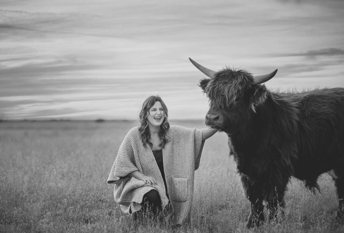 girl laughing and petting a mini highland cow in the panhandle of texas