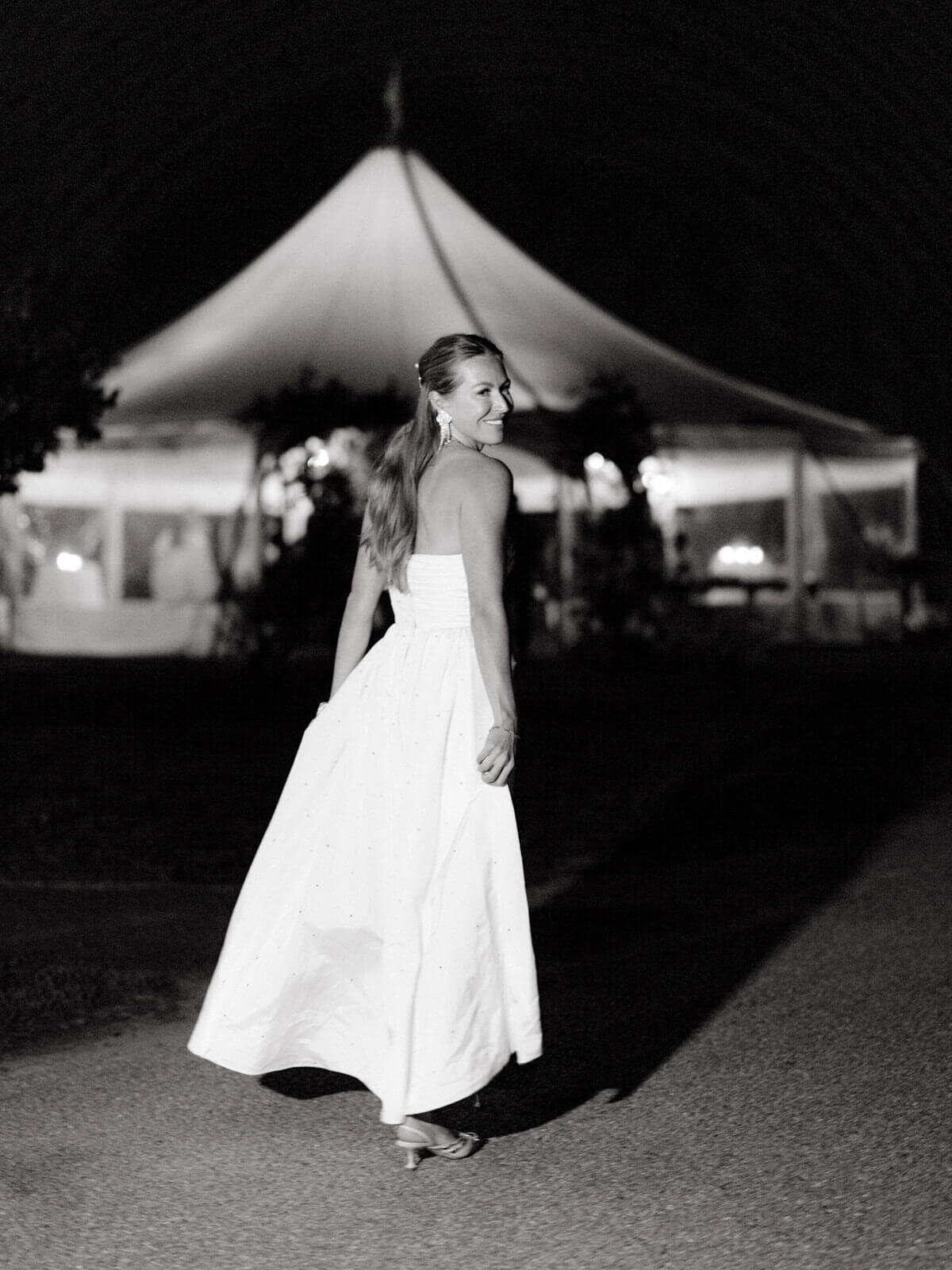 The bride is excitedly walking towards the wedding reception tent at The Ausable Club, NY. Image by Jenny Fu Studio