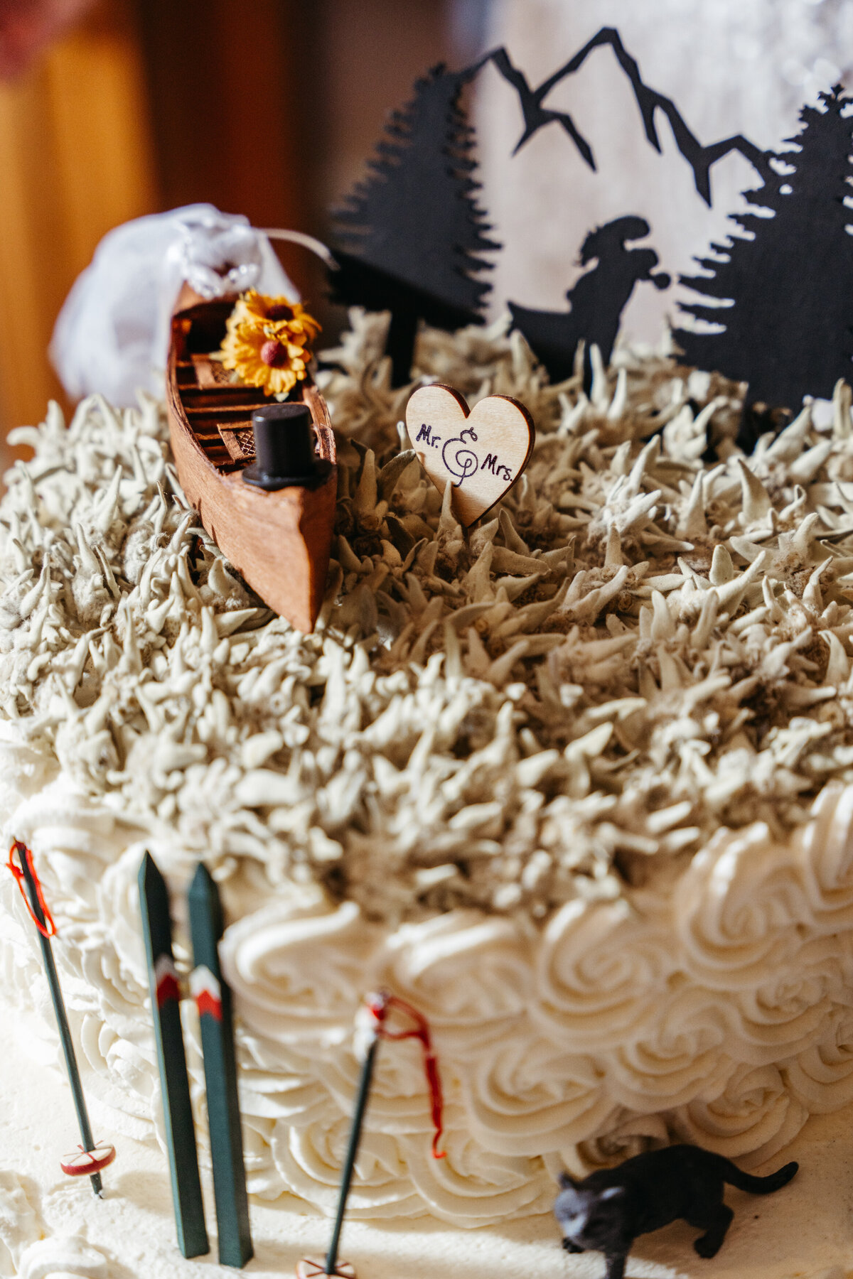 Unique adventure-themed wedding cake with mountain topper