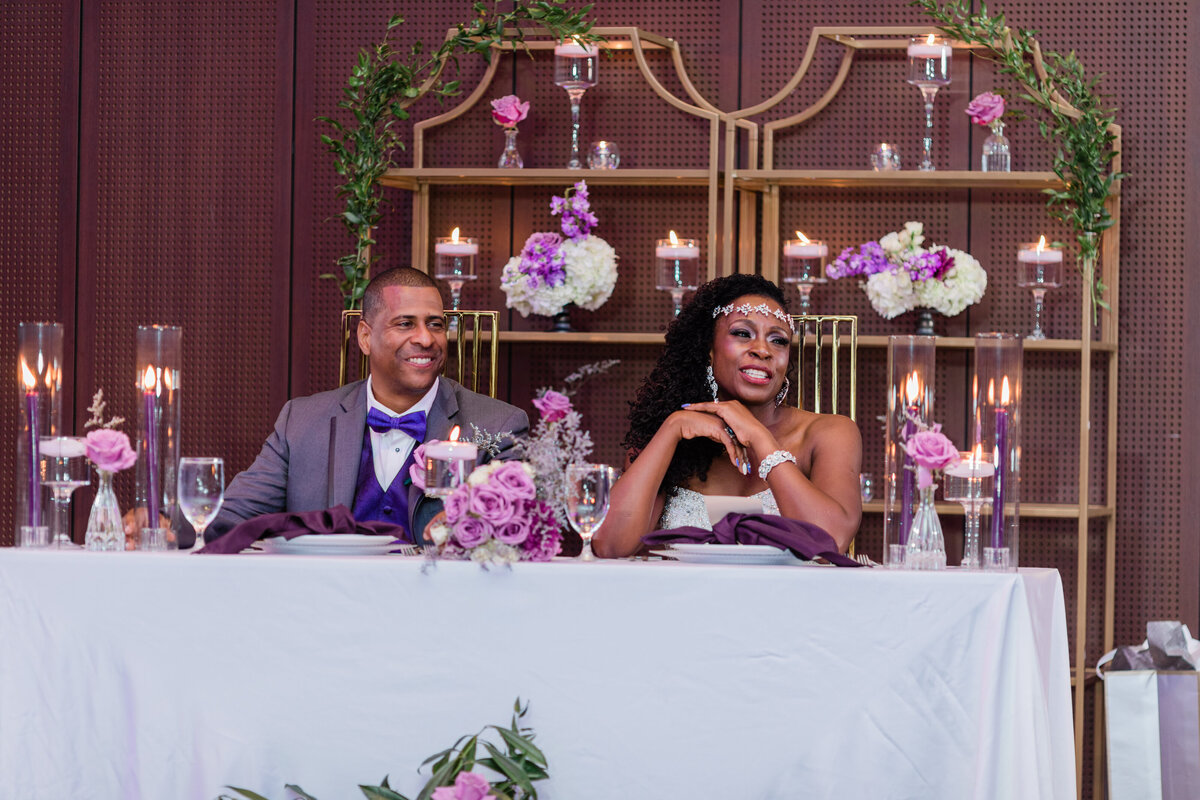 bride and groom enjoying reception with decorated shelves in the background