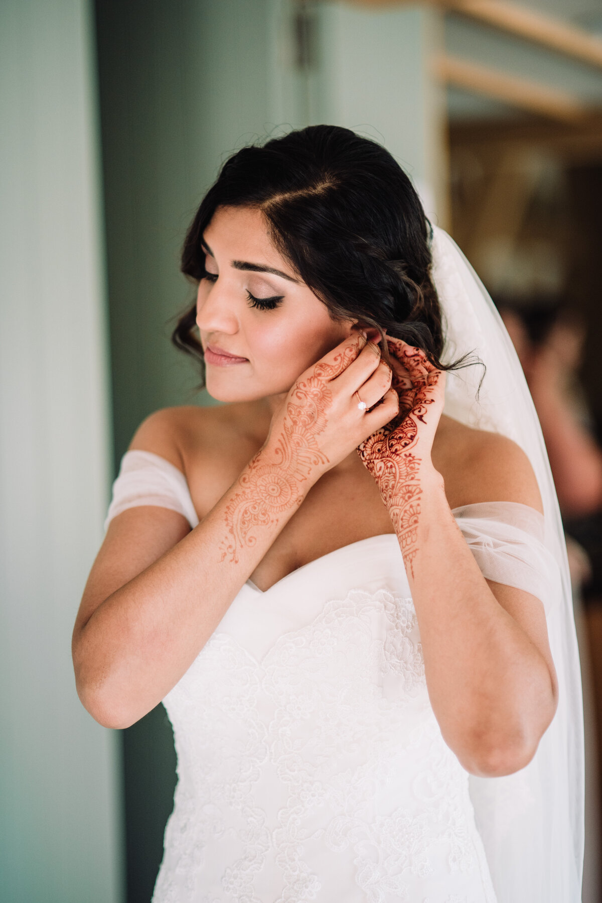 A bride putting earings in taken by London Wedding Photographer Liberty Pearl
