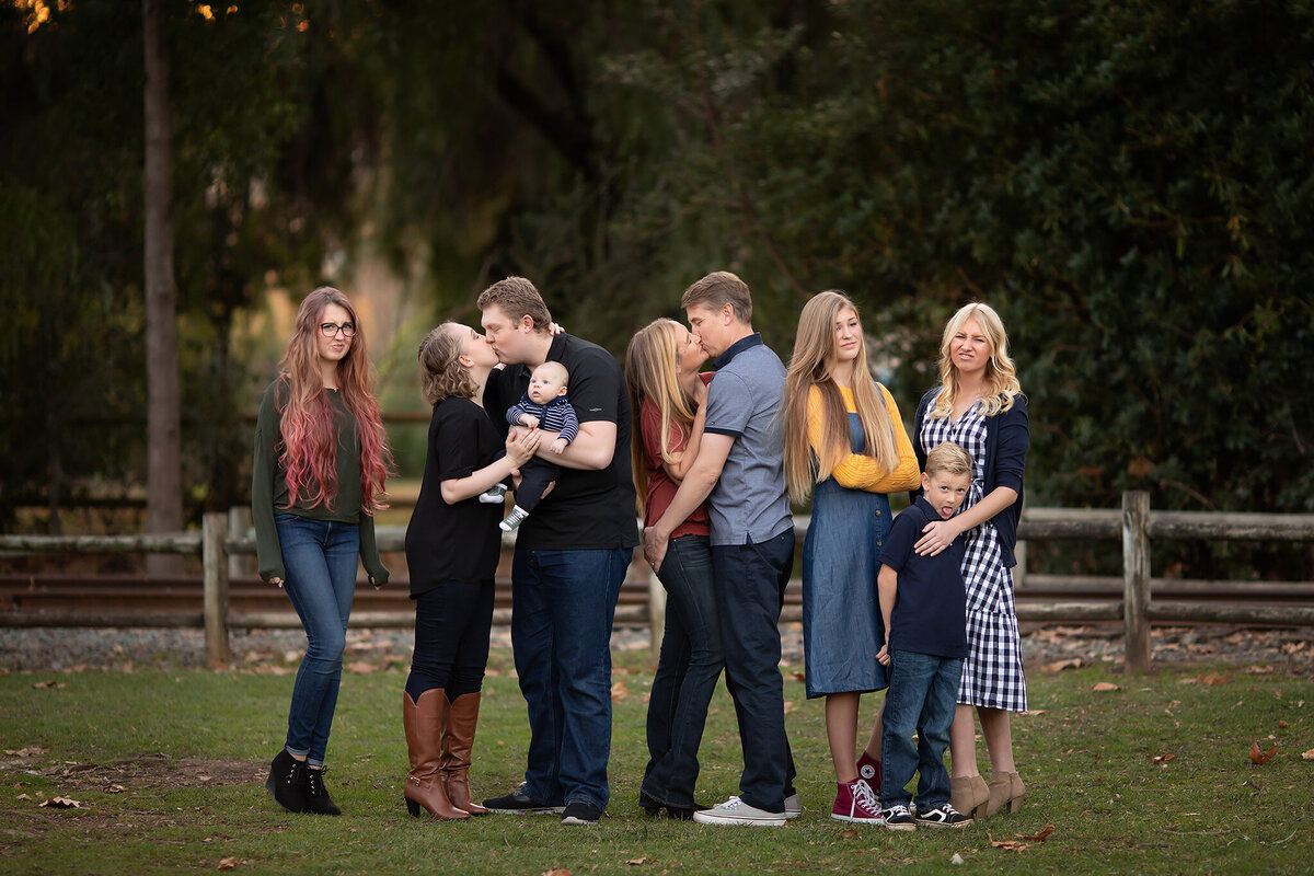 Dallas family photographers capturing a playful moment with multiple generations posing together outdoors.